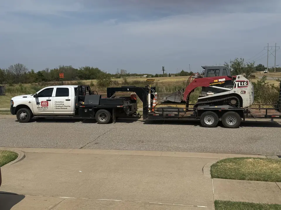 Mike's Bobcat Service truck towing a trailer with a Takeuchi TL10 track loader