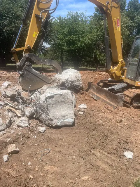 Excavator with broken concrete pieces